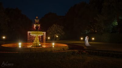 Bride and groom kiss by the fountain on their wedding day at Oulton Hall
