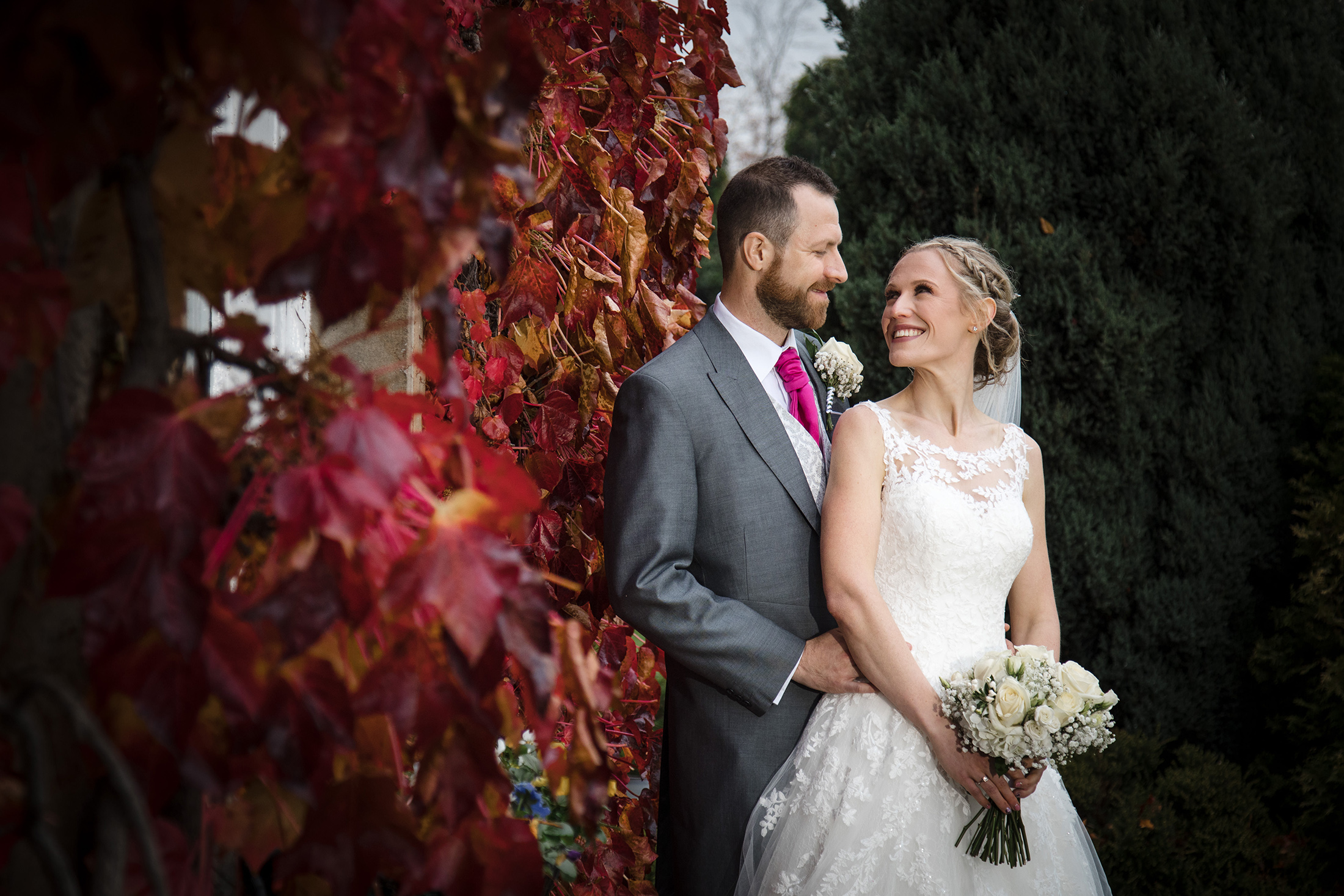 Bride and Gromm pose by Red Leaves at Waterton