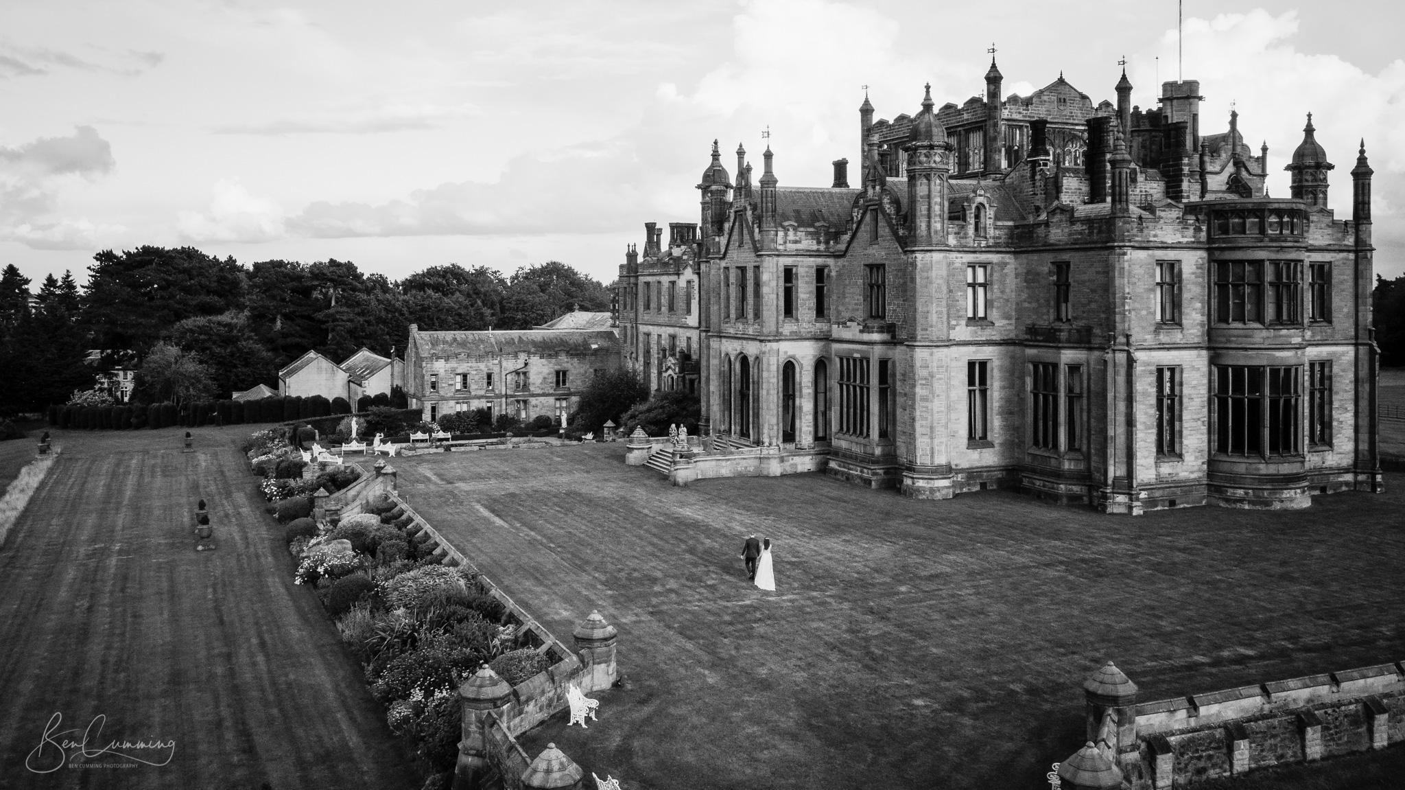 Drone Photo of a Bride and Groom walking towards Allerton Castle