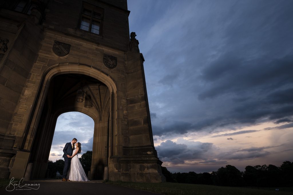 Bride and Groom Pose with a beautiful sky at Allerton Castle