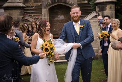 Bride and Groom Getting Covered in Confetti at Allerton Castle