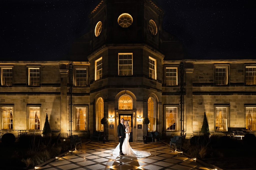 Bride and Groom Pose at night outside Grantley Hall