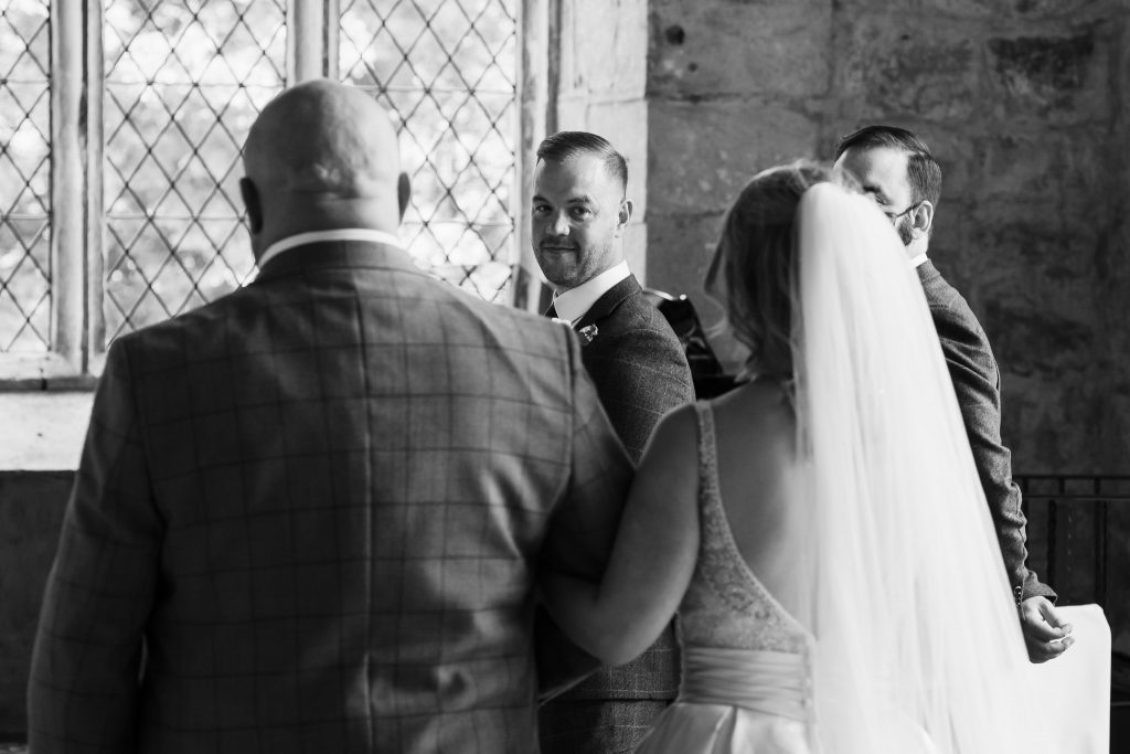 Groom watches Bride walk down the aisle at the Priests House Barden Tower