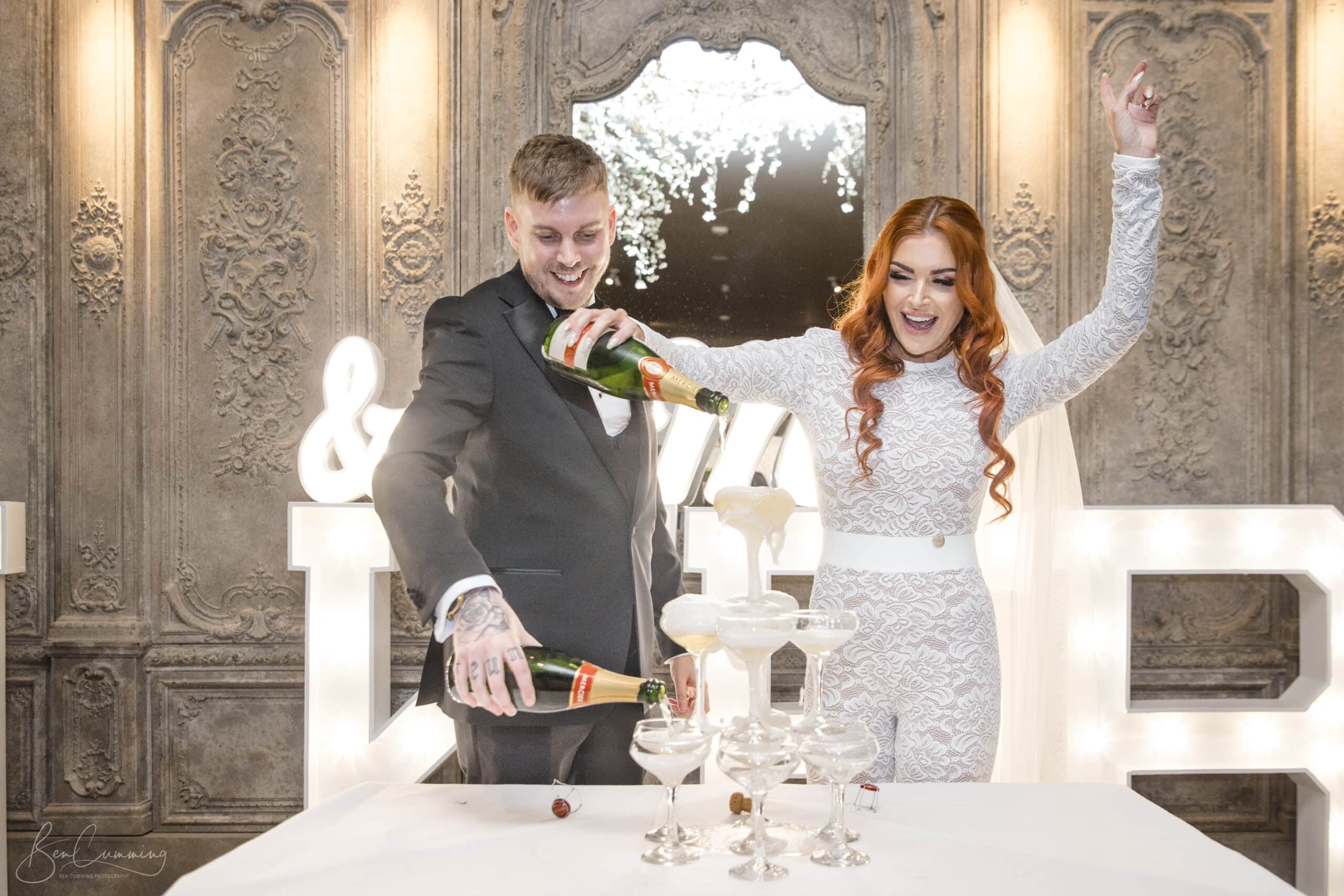 Newlyweds pouring a champagne tower during their wedding reception at The Croft Hotel